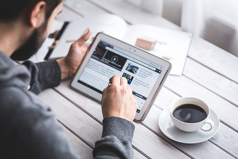 A man blog writing on his tablet
