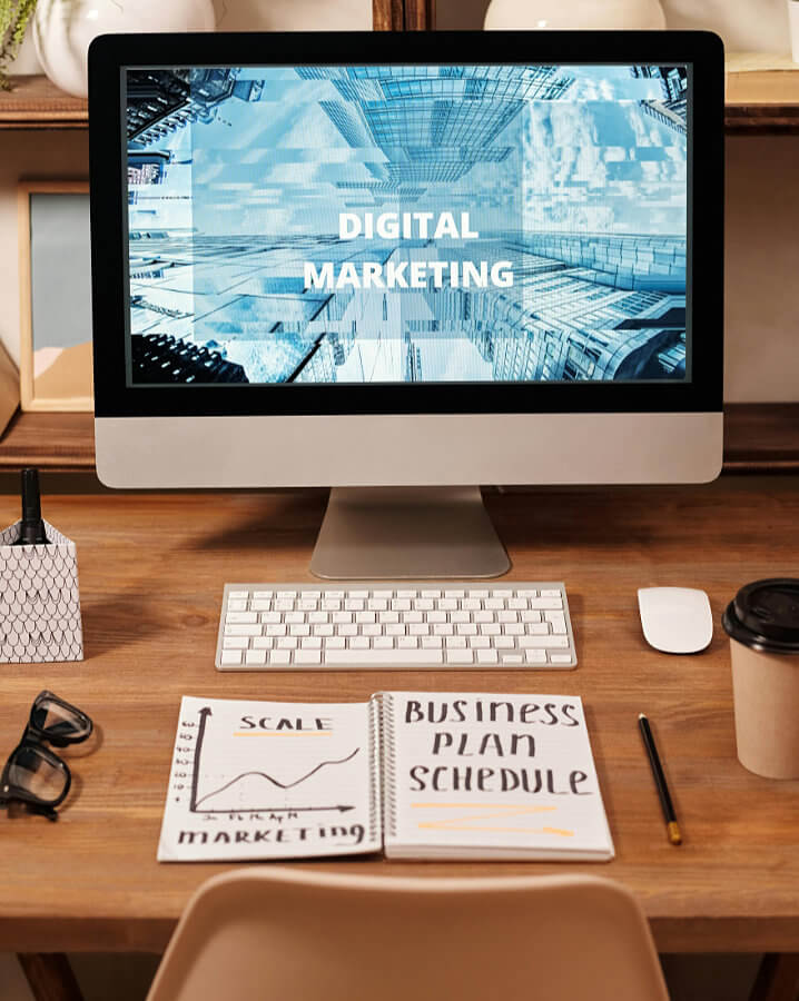 Virtual Marketing Manager with Digital Marketing on their computer screen and a notebook on the desk