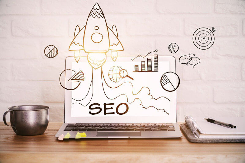 Virtual illustration of an SEO rocket taking off from the screen of a laptop